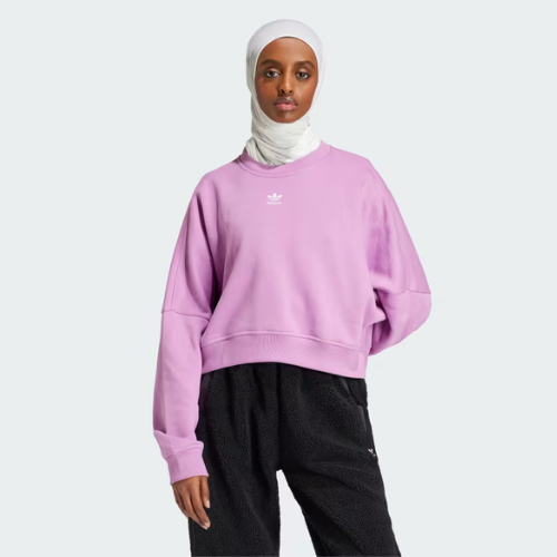 A model wearing a pinkish purple crewneck sweatshirt from adidas